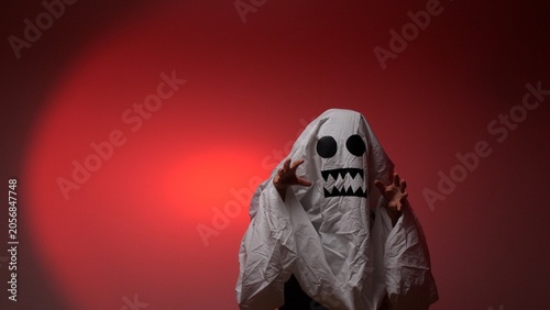 Canvas-taulu Child wearing a homemade white sheet ghost costume with black eyes and jagged te