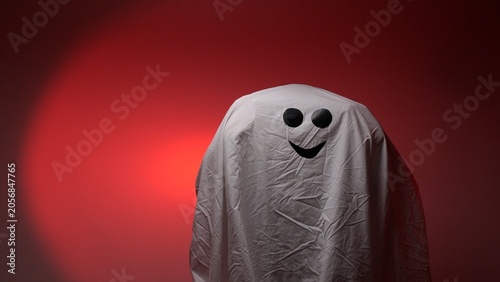 Εκτύπωση καμβά White sheet ghost costume featuring black eyes and a smiling mouth against a dar