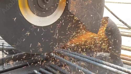 Industrial Power Chop Saw Cutting Heavy Duty Steel Rebar Rods with Bright Sparks Flying in Construction Site