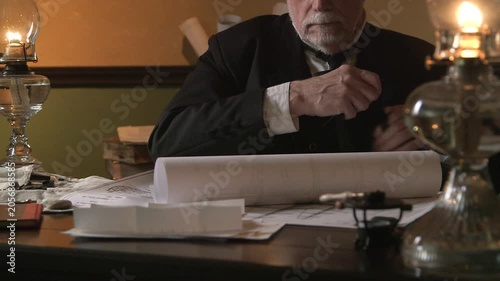 Naval architect of shipwright opening a drawing