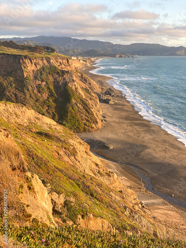 Foto Dramatic coastal cliffs extending to the horizon along the Pacific Ocean at gold