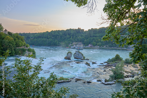 Rocky river rapids with trees and hills