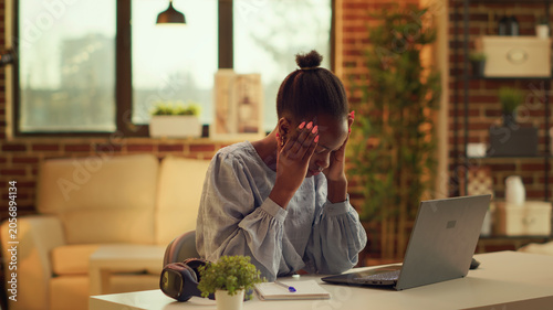 Bild auf Leinwand African American girl being in pain at home, suffering from extreme headache while trying to solve daily responsibilities