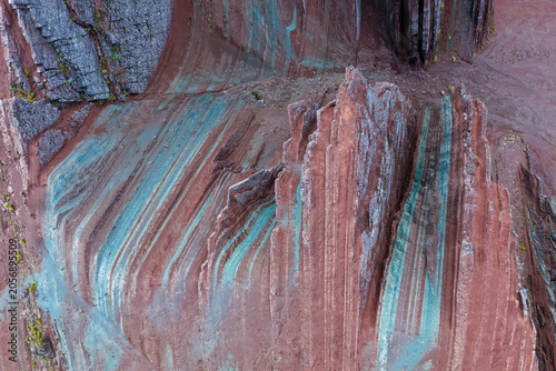 Bild auf Leinwand Reddish rock formations with turquoise veins seen by drone