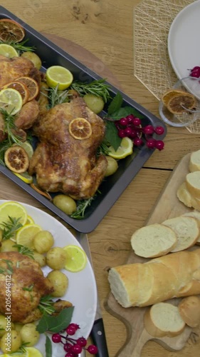 Vertical video: Sweeping camera showing table at home with roast chickens, napkins, bread for meal