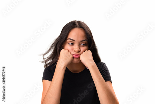 Bored young latina woman leaning on hands isolated on white background.