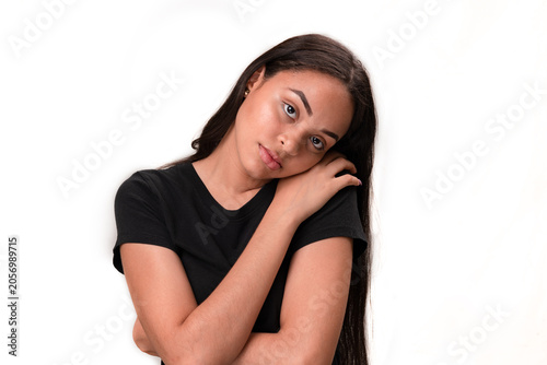Sad young latina woman leaning head on shoulder isolated on white background.