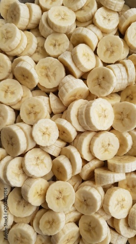 Banana slices overlapping background, top view full frame texture
