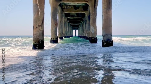 Slow motion of an incoming wave against the piles beneath the pier

