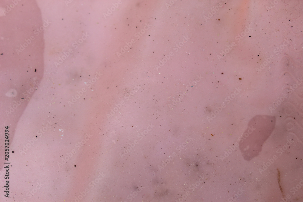 Fototapeta premium Crumpled pink rubber texture background with small dirt details and stain spots.