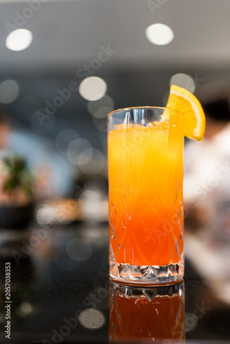 A delicious Malibu Sunset served in tall glass with a slice of fresh orange