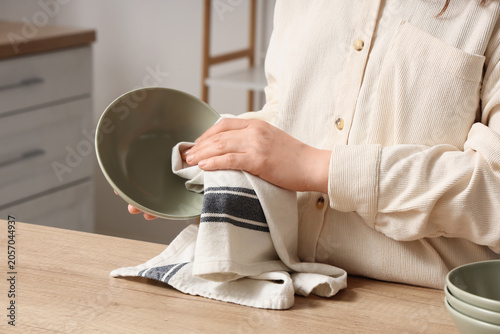 Woman drying clean bowl wit...