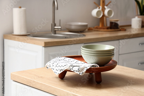 Obraz na płótnie Modern kitchen interior with wooden countertop, sink, paper towel, and stacked b
