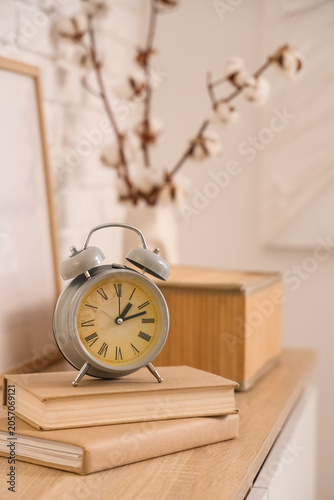 Alarm clock and books on ch...