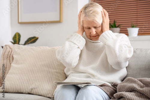 Senior woman on sofa suffer...