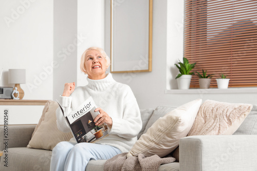 Senior woman with magazine ...