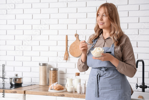 Smiling woman in apron eati...