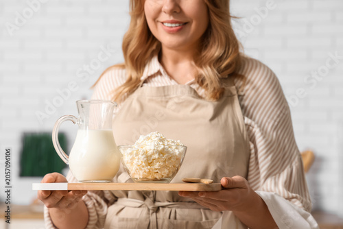 Smiling woman in apron hold...