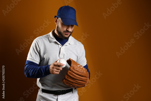 фотографія Baseball player in blue cap and white polo shirt holding ball and glove, ready f