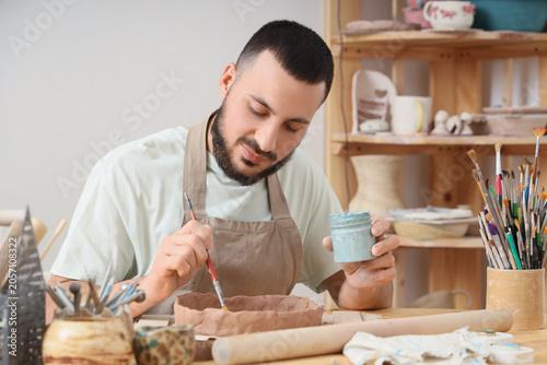 Young male artist painting ...