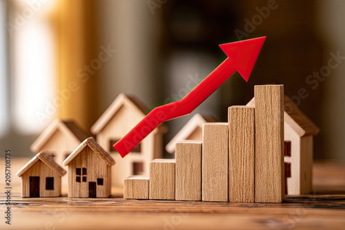Wooden houses and a rising red arrow chart show real estate market growth