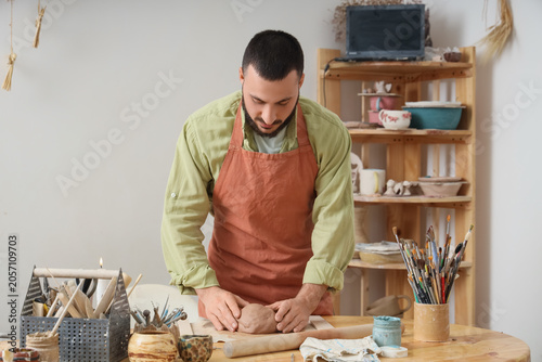 Male potter kneading clay o...