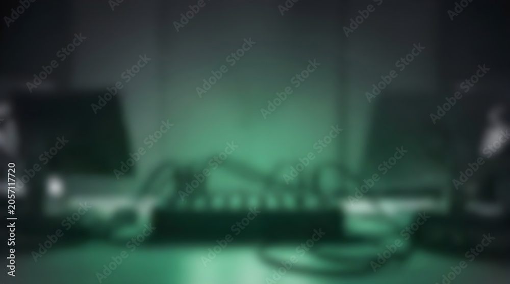 Naklejka premium Cinematic blurred server room background, dark green glowing data center equipment, abstract technology network hub with cables and monitors