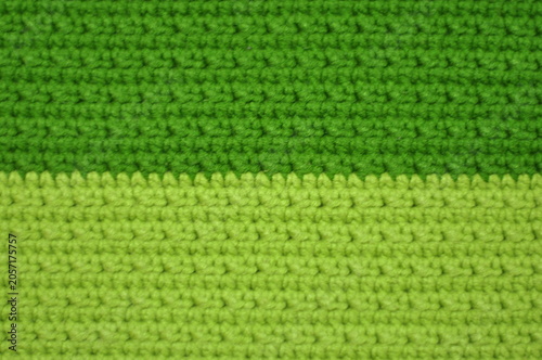 A green and yellow striped crochet pattern. The green stripe is the dominant color and the yellow stripe is a smaller accent. The pattern is made up of small