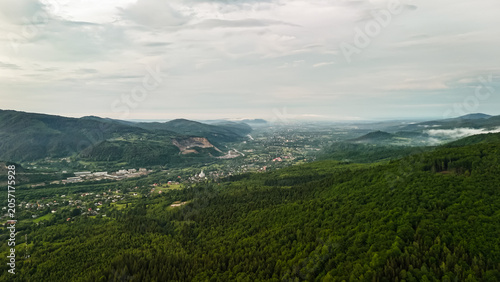 Tableau sur toile Expansive view from forested hills toward a sprawling valley town
