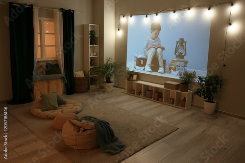 Quadro su tela Cozy home cinema setup with projector screen and string lights, comfortable floo