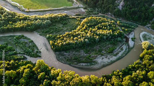 Top view of a sinuous river forming a tight loop around a green island