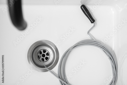Schilderij op canvas Sink with clogged drain and plumbers snake, top view