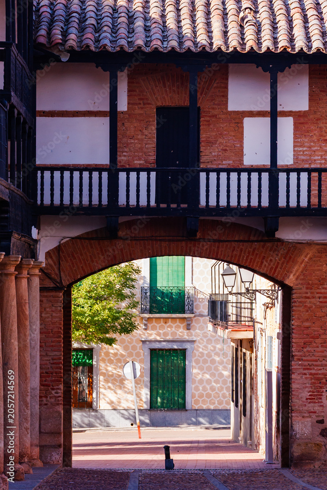 Naklejka premium Framed View of Town Streets via Plaza Mayor Arch