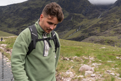 Man wearing fleece jacket hiking in scottish mountains