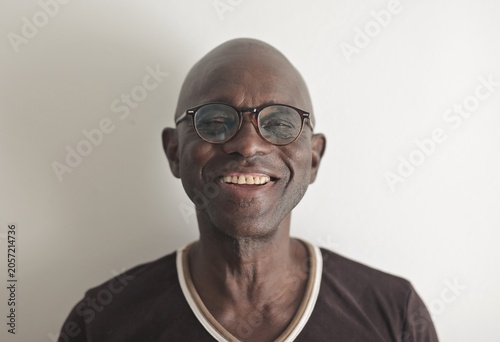 Quadro su tela Bald senior man with glasses smiling kindly