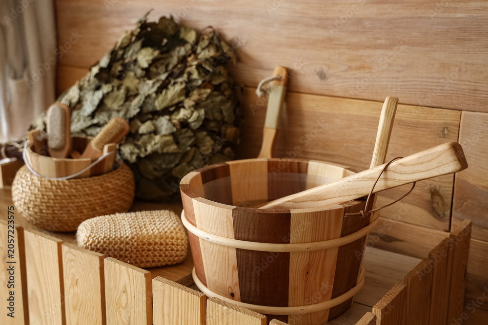 Obraz premium Bucket of water with loofah on counter in sauna, closeup