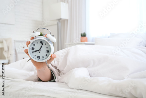 Young woman with alarm cloc...