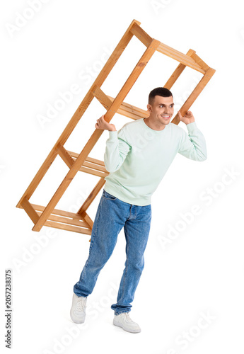 Young man carrying shelf un...