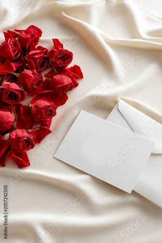 Red Roses and Blank Message Card on White Silk Fabric