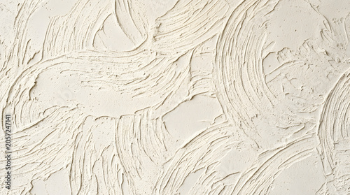 Textured Plaster Surface: A close-up of a lightly textured plaster wall with a unique swirling pattern, offering a sense of depth and organic design.