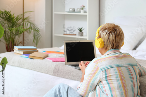 Mature woman with headphone...