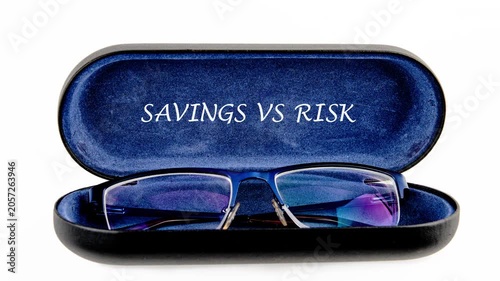 A close-up view of glasses in a case with the words savings vs risk. It looks at how these factors affect money choices and investments