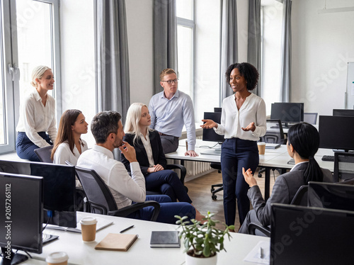 Fotografie Confident Black businesswoman presenting to diverse colleagues during an office meeting or training session