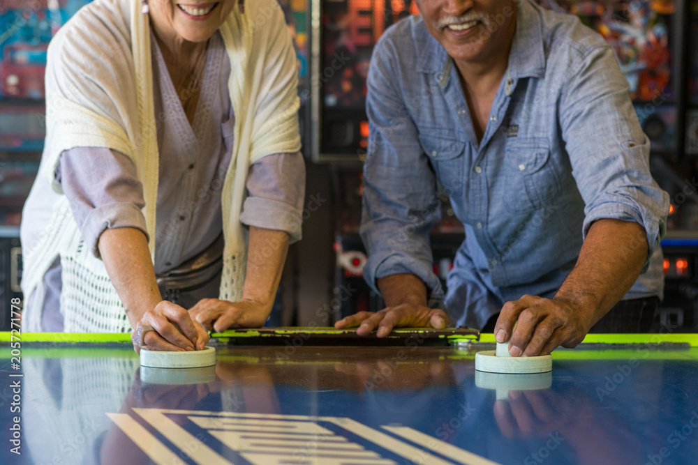 Fototapeta premium Couple enjoying air hockey game.