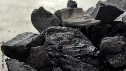 A collection of charcoal. Charcoal is a black, carbonaceous residue produced by burning wood without oxygen (pyrolysis). This material is widely used as a cooking fuel