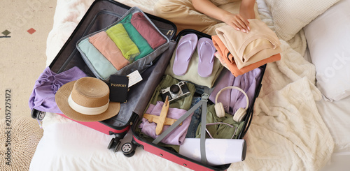 Young woman packing clothes...