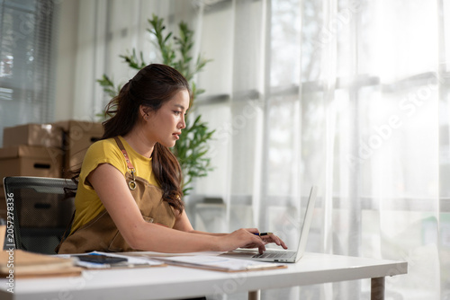 Young woman managing online business from home office