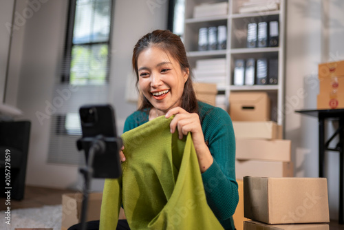 Asian woman live selling clothing online from home