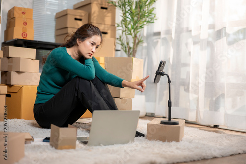 Woman feeling overwhelmed while managing online store from home