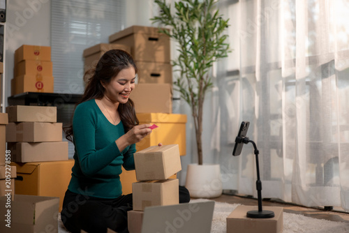 Smiling woman preparing packages for shipment in home office